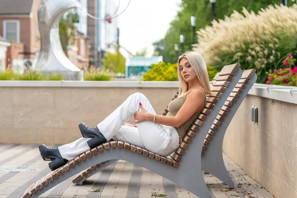 Sarışın bir model yaz gününün tadını çıkarırken dışarıda poz veriyor.