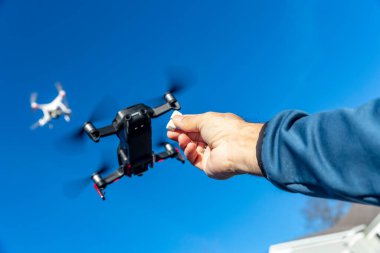 Bir grup dron havada mavi gökyüzüne karşı uçuyor.