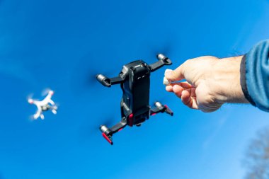 Bir grup dron havada mavi gökyüzüne karşı uçuyor.