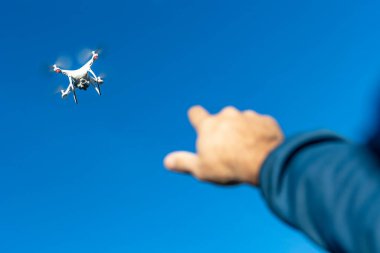 Bir grup dron havada mavi gökyüzüne karşı uçuyor.
