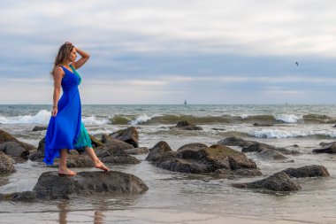 Güzel bir esmer İspanyol manken gün batımında sahilde poz veriyor.