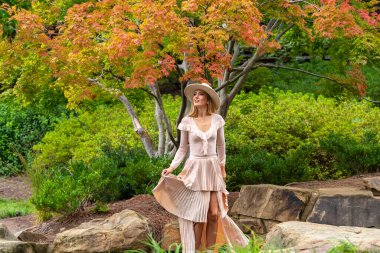 Sonbahar kıyafetleriyle dışarıda poz veren güzel bir sarışın manken.