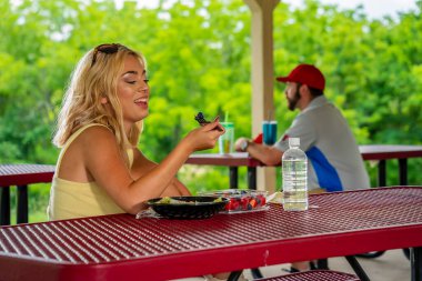 Sarışın bir manken, Covid-19 salgını sırasında diğerlerinden güvenli bir mesafede öğle yemeğinin tadını çıkarıyor.