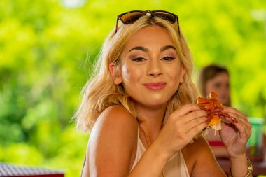 Sarışın bir manken, Covid-19 salgını sırasında diğerlerinden güvenli bir mesafede öğle yemeğinin tadını çıkarıyor.