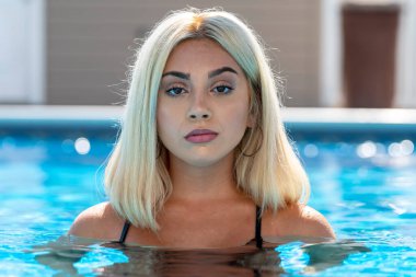 Sarışın bir manken yaz gününün tadını çıkarırken bikiniyle poz verir.