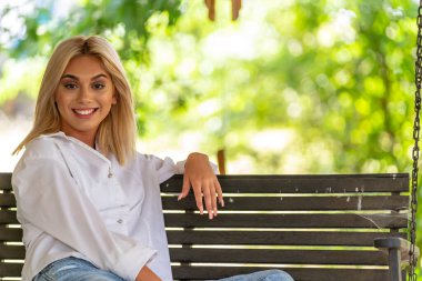 Sarışın bir model yaz gününün tadını çıkarırken dışarıda poz veriyor.