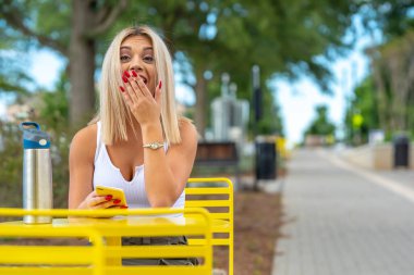 Sarışın bir model yaz gününün tadını çıkarırken dışarıda poz veriyor.