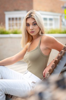 Sarışın bir model yaz gününün tadını çıkarırken dışarıda poz veriyor.