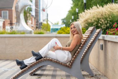 Sarışın bir model yaz gününün tadını çıkarırken dışarıda poz veriyor.