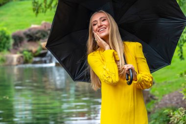 Sonbahar kıyafetleriyle dışarıda poz veren güzel bir sarışın manken.