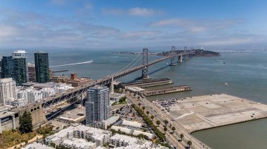 SAN FRANCISCO, CA USA - 28 Temmuz 2025: San Francisco Körfezi boyunca uzanan Bay Köprüsü 'nü, San Francisco ve Oakland' ı çift güverteleri ve çarpıcı süspansiyon tasarımı ile bağlayan bir hava görüntüsü yakaladı..