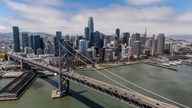 SAN FRANCISCO, CA USA - 28 Temmuz 2025: San Francisco Körfezi boyunca uzanan Bay Köprüsü 'nü, San Francisco ve Oakland' ı çift güverteleri ve çarpıcı süspansiyon tasarımı ile bağlayan bir hava görüntüsü yakaladı..