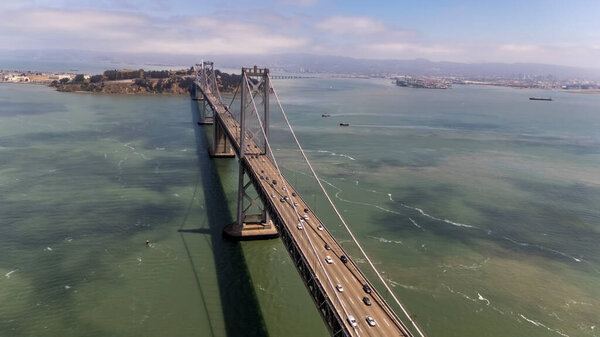 САН-ФРАНЦИСКО, Калифорния, США - 28 июля 2025 года: С высоты птичьего полета виден мост через залив Сан-Франциско, соединяющий Сан-Франциско и Окленд с двумя палубами и поразительной конструкцией подвески..
