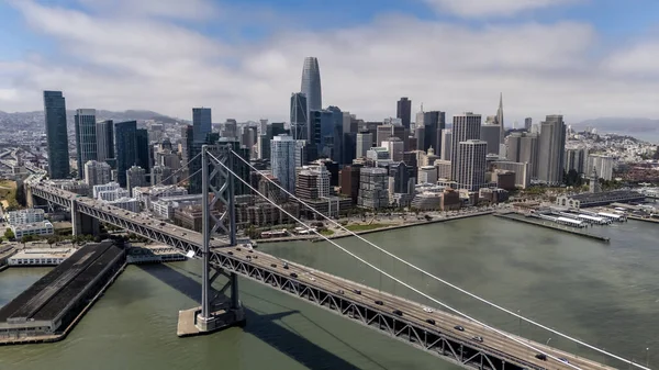 SAN FRANCISCO, CA USA - 28 Temmuz 2025: San Francisco Körfezi boyunca uzanan Bay Köprüsü 'nü, San Francisco ve Oakland' ı çift güverteleri ve çarpıcı süspansiyon tasarımı ile bağlayan bir hava görüntüsü yakaladı..