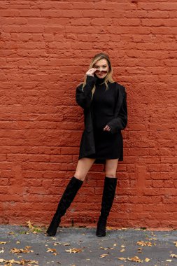 Muhteşem sarışın bir kadın, rahat bir elbise ve cekete sarılmış küçük bir kasabada geziniyor. Altın yapraklarla çevrili, sıcacık gülümsüyor, temiz havanın ve büyüleyici manzaranın tadını çıkarıyor..