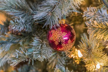 Parıldayan Noel ışıkları ve parıldayan süsler ağacı süslüyor, Noel sezonunu neşe, merak ve ebedi gelenekle dolduran ılık bir ışıltı saçıyor..