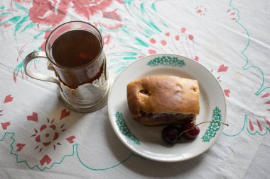 Masanın üzerinde bir eski Rus bardak tutucu Tea. Kirazlı turta ile.