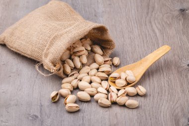 Pistachio 'yu ahşap masanın üstündeki çantaya koy.