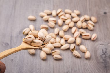 Tahta masada kaşıkla fıstıklı