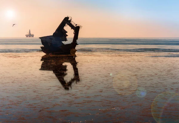 Fartygets vraket på bakgrunden av en oljeplattform i — Stockfoto