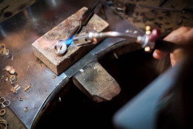 Kuyumcu altın bir yüzük bir otantik takı Atölyesi meşale kaynak alev ile tezgah üzerinde lehimleme