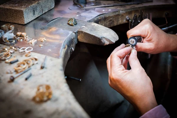珠宝商在正宗珠宝车间的旧工作台上擦亮金戒指 — 图库照片