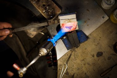 Kuyumcu ile dökülen erimiş gümüş ya da altın Kuyumcu Atölyesi'nde metal formundaki alev