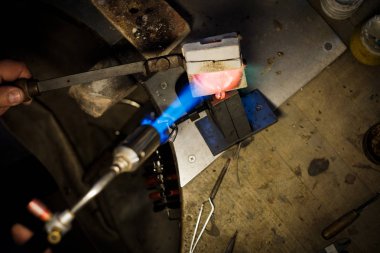 Kuyumcu ile dökülen erimiş gümüş ya da altın Kuyumcu Atölyesi'nde metal formundaki alev