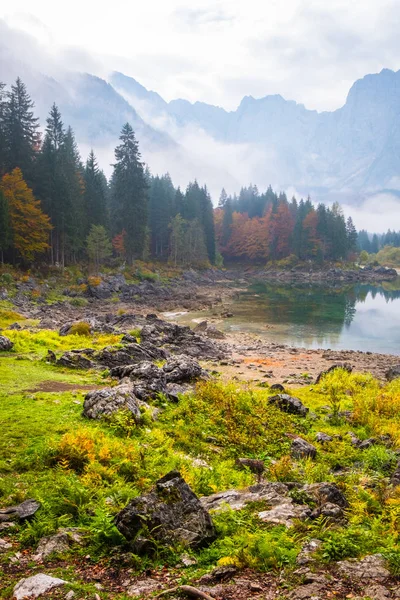 在一个雾蒙蒙的早晨 在意大利 Tarvisio 附近的海滩和山脉 Mangart 可以看到 Laghi Fusine 湖的景色 — 图库照片