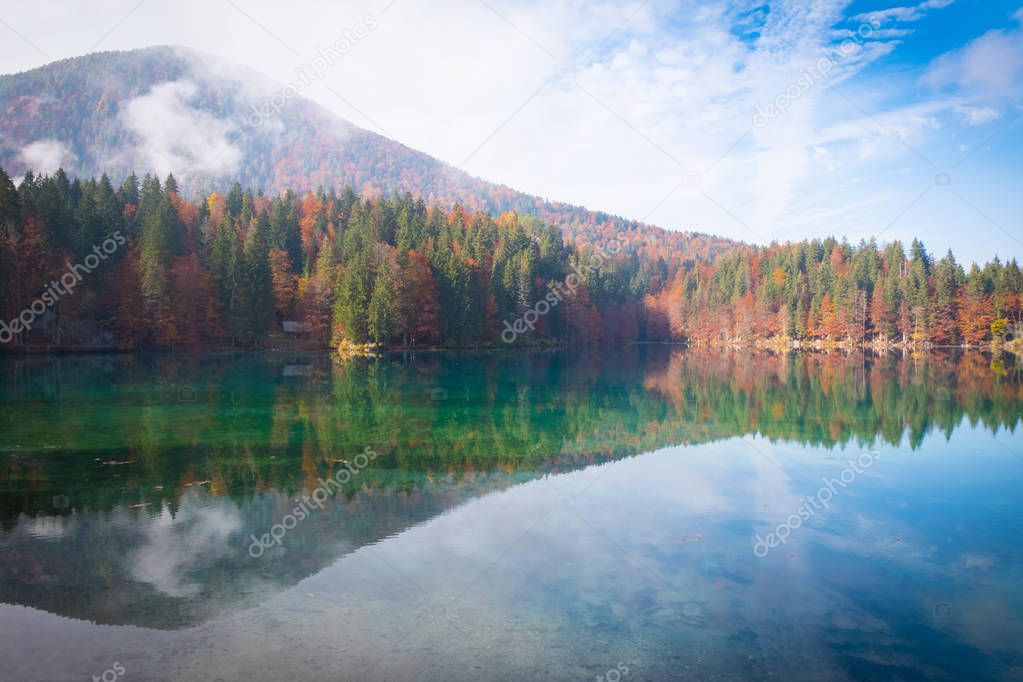 View over lake Laghi di Fusine to mountain range Mangart near Tarvisio in Italy on a sunny morning in autumn
