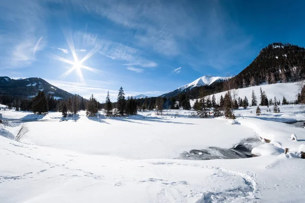 Snow covered frozen lake in holiday-resort Hohentauern on a sunny winter day in Styria, Austria
