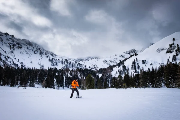 冬には雪のスノーシュー オレンジ色のジャケットを持つ男おおわグローサー Hengst グローサー Boesenstein Hauseck 山を一望リゾート Hohentauern Scheibelalm — ストック写真