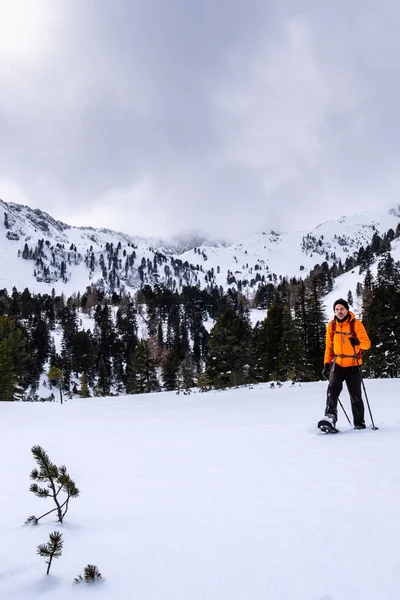 冬には雪のスノーシュー オレンジ色のジャケットを持つ男おおわグローサー Hengst Grssoer Boesenstein Hauseck 山を一望リゾート Hohentauern Scheibelalm — ストック写真