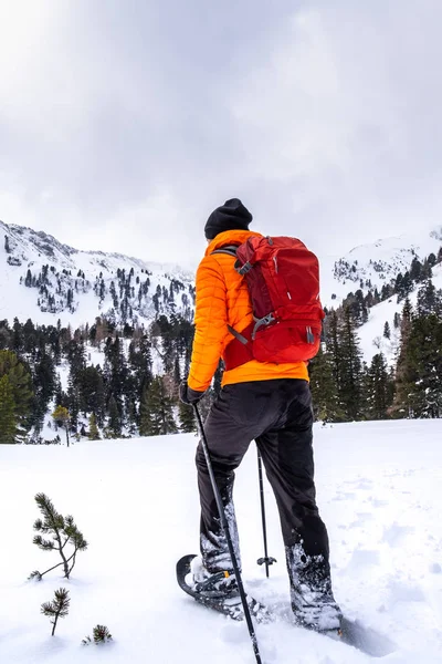 在度假村 Hohentauern 穿着橙色夹克的人在雪上穿雪 冬季可以欣赏到格罗斯尔 亨斯特 格罗斯尔 博森斯坦和豪塞克的山景 — 图库照片