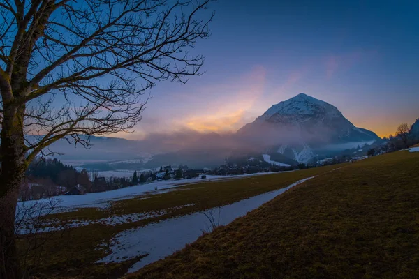 View from a field near village Puergg to sunset over mountain Grimming in Styria, Austria