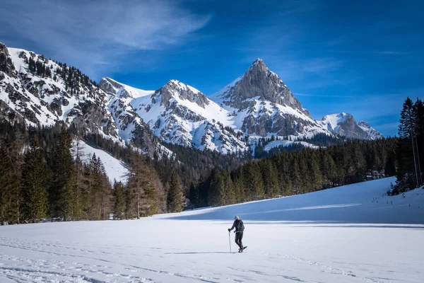 Hombre raquetas de nieve en la meseta nevada Kaiserau con montaña Admonter — Foto de Stock