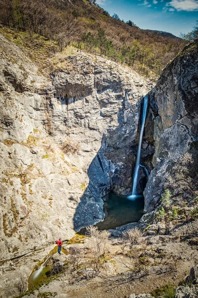 Hombre parado cerca de la cascada en el parque natural Rosandra cerca de Triest — Foto de Stock