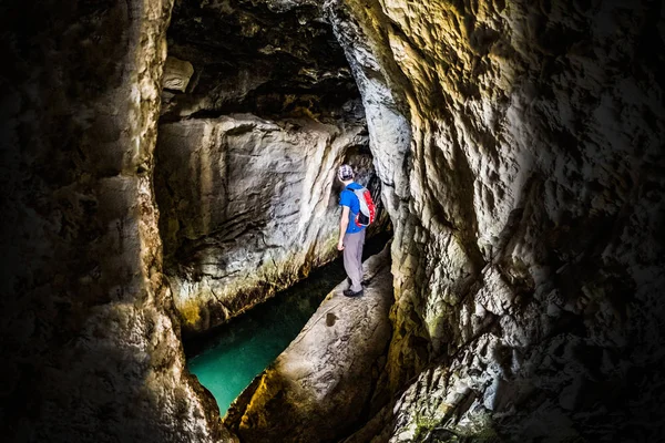 Hombre explorando cueva smale con agua en el parque nacional Rosandra — Foto de Stock