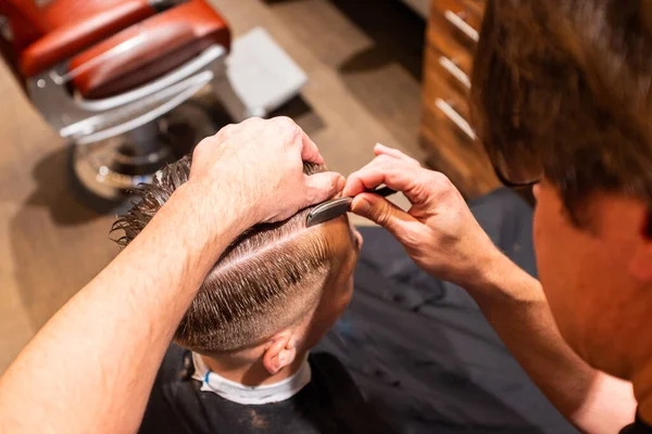 Berber Berber Dükkanında Bir Jiletle Genç Bir Adamın Saçını Kesiyor - Stok İmaj