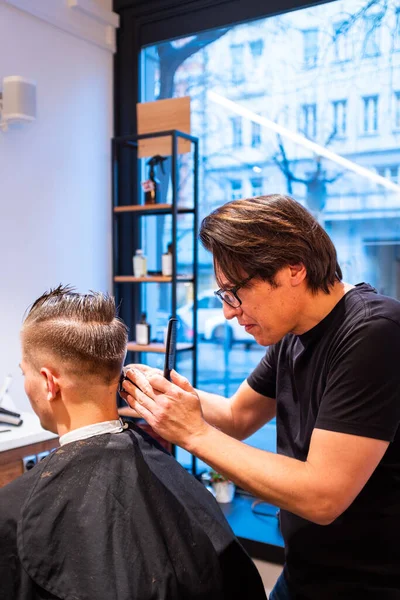 Berber Berber Dükkanında Ustura Olan Genç Bir Adamın Saçını Kesiyor Stok Resim