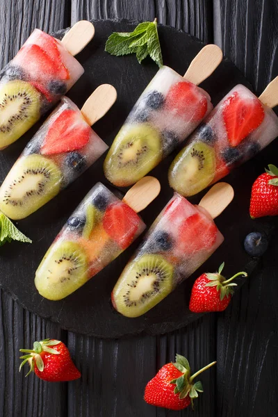 水果冰在一根草莓 猕猴桃和蓝莓与薄荷特写在桌子上的盘子 Abov 垂直顶部视图 — 图库照片