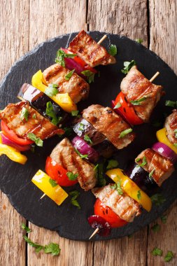 Taze domuz eti şiş bir tabloda kayrak bir tabakta sebze yakın çekim ile hazırlanmış. Abov gelen dikey üstten görünüm