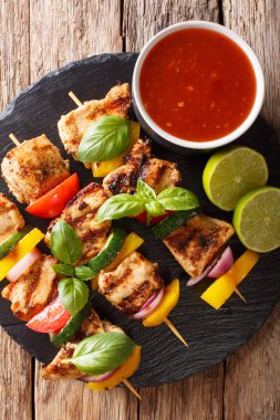 masanın üzerine sosu, fesleğen ve kireç closeup ile yaz sebzeli ızgara tavuk şiş. Abov gelen dikey üstten görünüm