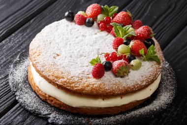 Victoria sandviç kek çilek, ahududu, Bektaşi, kuş üzümü ve nane closeup masanın üzerinde. Horizonta