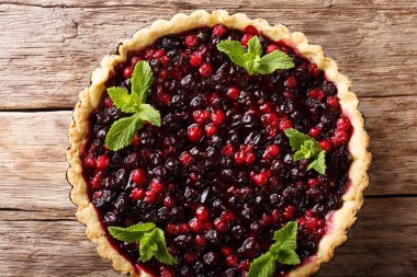 Frenk üzümü çilek, yaban mersini ve kızılcık yakın çekim bir pişirme çanağı bir tablo içinde ile rustik sulu tart. Abov üzerinden yatay üstten görünüm