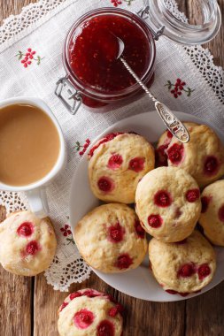 Kırmızı kuş üzümü ile İngilizce aplikler bisküvi tabloda çay ve süt yakın çekim ile servis edilir. Abov gelen dikey üstten görünüm
