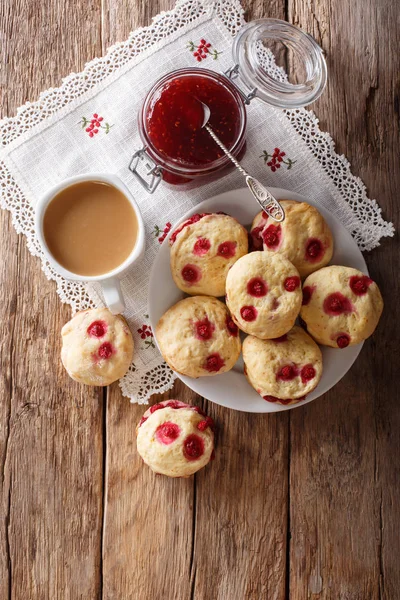 İngiliz çöreği aplikler kırmızı kuş üzümü ile masaya İngilizce çay ve reçel yakın çekim ile servis edilir. Abov gelen dikey üstten görünüm