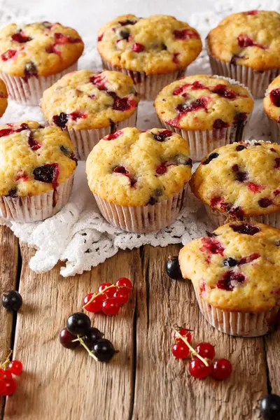 Taze kekler masanın üzerine siyah ve kırmızı frenk üzümü çilek yakın çekim ile. Vertica