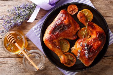 Fransız gıda: kızarmış çeyrek tavuk lavanta tatlım, baharat ve limon yakın masada bir plaka üzerinde çekim bacaklar. Abov üzerinden yatay üstten görünüm