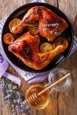 Fransız gıda: kızarmış çeyrek tavuk lavanta tatlım, baharat ve limon yakın masada bir plaka üzerinde çekim bacaklar. Abov gelen dikey üstten görünüm